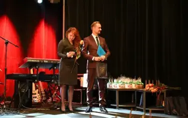 widzimy pana trzymającego torbe prezentową oraz panią trzymającą r&oacute;że