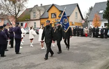 widzimy orkiestre oraz grupe dziewczyn z pomponami oraz idącą grupe ze sztandarami