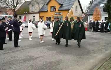 widzimy orkiestre oraz grupe dziewczyn z pomponami oraz idącą grupe ze sztandarami