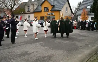 widzimy orkiestre oraz grupe dziewczyn z pomponami oraz idącą grupe ze sztandarami