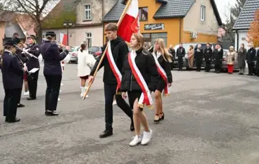 widzimy orkiestre oraz grupe dziewczyn z pomponami oraz idącą grupe ze sztandarami
