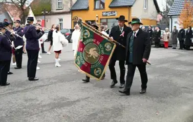 widzimy orkiestre oraz grupe dziewczyn z pomponami oraz idącą grupe ze sztandarami