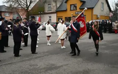 widzimy orkiestre oraz grupe dziewczyn z pomponami oraz idącą grupe ze sztandarami