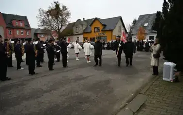 widzimy orkiestre oraz grupe dziewczyn z pomponami oraz idącą grupe ze sztandarami