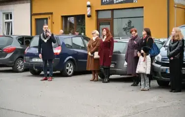 widzimy pana Burmistrza m&oacute;wiącego przez mikrofon oraz dwie osoby stojące obok niego