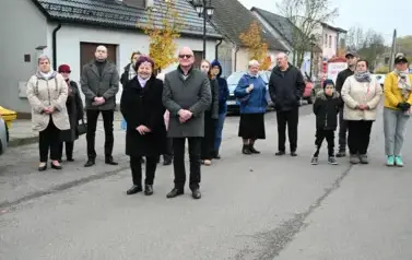 widzimy grupę os&oacute;b stojącą przed budynkiem 
