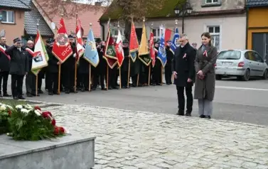 widzimy pania i pana stojących przed pomnikiem