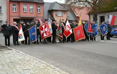 widzimy grupę os&oacute;b ze sztandarami