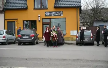 widzimy pana Burmistrza z wieńcem oraz kilka os&oacute;b stojących obok