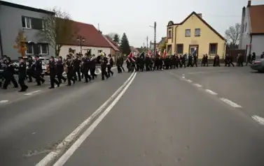 widzimy idące po ulicy dziewczyny z pomponami a za nimi idzie orkiestra oraz sztandary