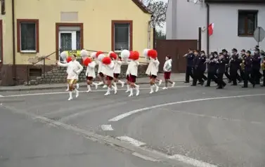 widzimy idące po ulicy dziewczyny z pomponami a za nimi idzie orkiestra