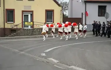 widzimy idące po ulicy dziewczyny z pomponami a za nimi idzie orkiestra