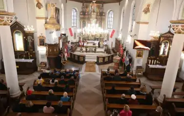 widzimy dużą ilość osob oraz ołtarz 