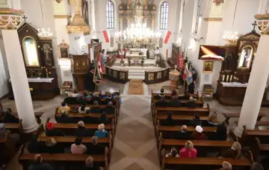 widzimy dużą ilość osob oraz ołtarz 