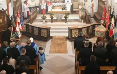 widzimy dużą ilość oso&oacute;b w kościele oraz ołtarz 