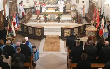 widzimy dużą ilość oso&oacute;b w kościele oraz ołtarz 