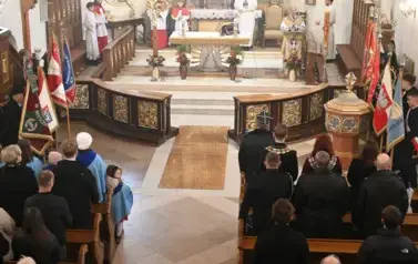 widzimy dużą ilość oso&oacute;b w kościele oraz ołtarz 