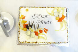 Na zdjęciu znajduje sie tort z napisem "50 lat pracy"