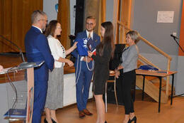 Na zdjęciu w&oacute;jt, pani dyrektor i radny wręczają stypendium dziewczynie. Obok stoi matka.