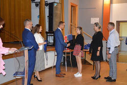 Na zdjęciu w&oacute;jt wręcza stypendium dziewczynce. Obok stoją jej rodzice.