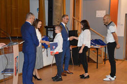 Na zdjęciu pani dyrektor gratuluje chłopcu stypendium. Pan w&oacute;jt natomiast przekazuje gratulacje jego rodzicom.