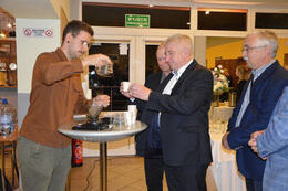 Na zdjęciu barista częstuje kawą gości.