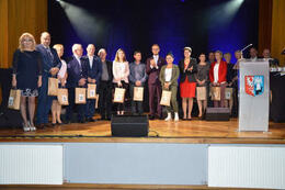 Na zdjęciu widać w&oacute;jta Gminy Mieścisko wraz z Przewodniczącą Gminy Mieścisko w otoczeniu przedsiębiorc&oacute;w. Znajdują się na scenie. Wszyscy trzymaja nagrody.