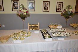 Zdjęcie przedstawia st&oacute;ł zastawiony przekąskami. Stoją ozdobne kielichy z kwiatami.