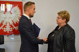 Na zdjęciu W&oacute;jt Gminy Mieścisko wręcza nagrodę pani dyrektor przedszkoloa. Kobieta ubrana jest w ciemną bluzkę i marynarkę. Ma kr&oacute;tkie, jasne włosy i okulary.