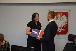 Na zdjęciu w&oacute;jt Gminy Mieścisko wręcza nagrodę nauczycielce ubranej w czarną bluzkę i spodnie, ma ona ciemne włosy i jest uśmiechnięta.