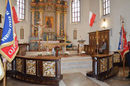 Na zdjęciu widać ołtarz kościoła w Mieścisku. Wiszą na nim flagi Polski. Przed ołtarzem stoją sztandary.