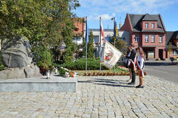 Na zdjęciu widać poczetSzkoły Podstawowej w Mieścisku przed pomnikiem ofiar II Wojny Światowej.