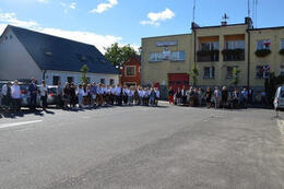 Zdjęcie przedstawia plac na rynku gdzie odbywa się apel. Widać na nim zgromadzonych ludzi.