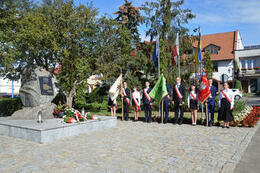 Na zdjęciu widać pomnik upamiętniający ofiary II Wojny Światowej. Na pomniku znajdują się kwiaty, znicze. Obok stoją delegacje ze sztandarami od lewej strony Szkoły Podstawowej w Mieścisku, Gminy Mieścisko, Szkoły Podstawowej w Popowie Kościelnym.