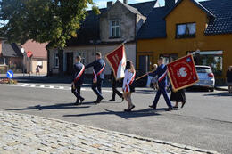 Zdjęcie przedstawia przechodzące delegacje ze sztandarami.