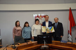 Zdjęcie przedstawia wsp&oacute;lną fotografię. od lewej strony trzy opiekunki młodzieży ukraińskiej. Następnie W&oacute;jt Gminy Mieścisko. Obok w&oacute;jta starszy mężczyzna, prezes stowarzyszenia, kt&oacute;re przyczyniło się do przyjazdu Ukrińc&oacute;w do Mieściska.