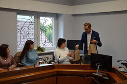 Zdjęcie przedstawia w&oacute;jta wręczjącego paczki z podarunkami gościom z Ukrainy.