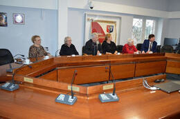 Zdjęcie przedstawia gości z Niemiec siedzących wzdłuż stołu na sali sesyjnej.