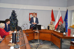 Na zdjęciu widać przemawiającego W&oacute;jta Gminy Mieścisko. Znajduje się on na sali sesyjnej. Wzdłuż stołu siedza goście z Niemiec.