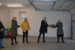 Zdjęcie przedstawia kilka os&oacute;b podających sobie prezenty w celu przeniesienia ich do wyznacoznego miejsca. Są to zar&oacute;wno kobiety jak i mężczyźni.