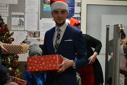 Zdjęcie przedstawia W&oacute;jta Gminy Mieścisko w czapce Mikołaja, trzymającego prezent.