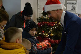 Na zdjęciu W&oacute;jt wręcza prezent dziecku. 