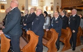 Zdjecie przedstawia strażak&oacute;w z gminnych jednostek OSP stojących w ławkach kościoła. 