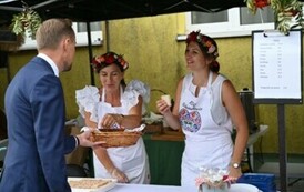 Burmistrz rozdaje chleb dożynkowy