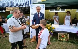 Burmistrz rozdaje chleb dożynkowy