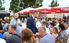 Burmistrz rozdaje chleb dożynkowy