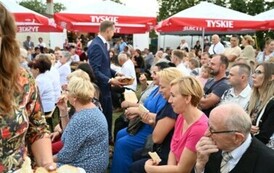 Burmistrz rozdaje chleb dożynkowy