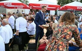Burmistrz rozdaje chleb dożynkowy