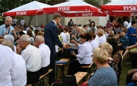 Burmistrz rozdaje chleb dożynkowy