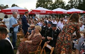 Burmistrz rozdaje chleb dożynkowy